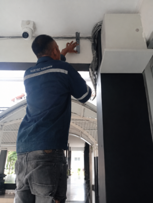 Teknisi menentukan titik pemasangan horn speaker sekolah