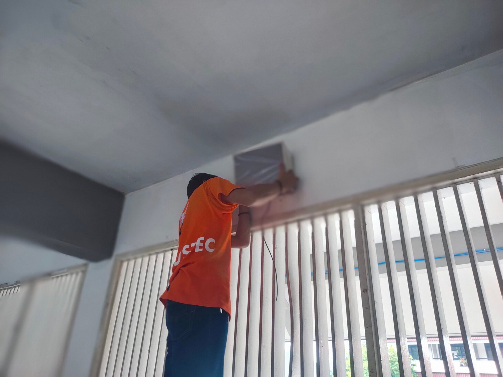 Pemasangan Speaker Paging System Teknisi memasang speaker indoor paging system di sekolah
